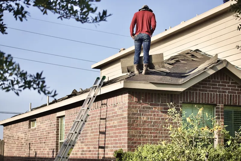 Professional roofer working on a residential roof in West Brewster
